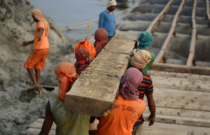 Những tấm tà vẹt bằng gỗ là vật liệu dùng để lát trên cầu. Đa phần các hoạt động trong quá trình xây dựng vẫn dùng đến sức người. Ảnh: Sanjay Kanojia/AFP.
