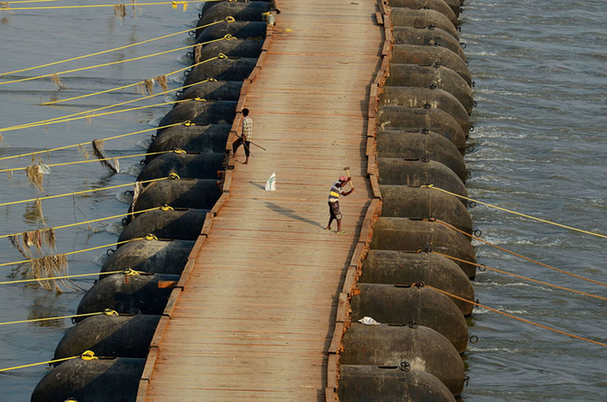 Mặt cầu sau khi đã phủ các tấm tà vẹt gỗ. Các phao thép cũng đã được gia cố bằng dây thừng. Ảnh: Sanjay Kanojia/AFP.