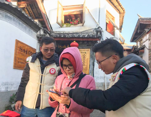 Tình nguyện viên du lịch giúp khách tìm đường tại Lệ Giang cổ trấn.