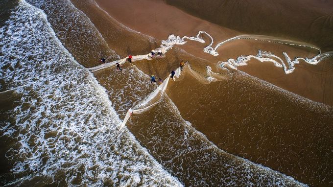 Nhóm ngư dân kéo lưới vào sáng sớm trên bãi biển Vũng Tàu trong Top ảnh đẹp tháng 9/2018.