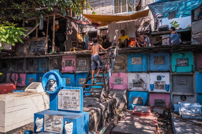 Nghĩa trang Bắc Manila (Philippines) là nơi được mệnh danh "chỗ người chết ở cùng người sống". Đây cũng là khu vực sinh sống của 10.000 người dân Philippines nghèo khó. Họ dựng nhà tạm bợ trên những ngôi mộ, hoặc lăng còn trống. Tại đây, người dân ăn, ngủ, xem tivi, phơi quần áo, chăm sóc con cái và thậm chí là hát karaoke.