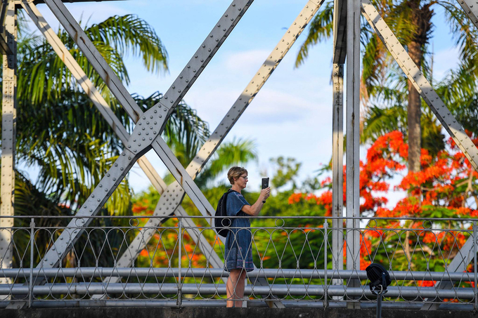 Du khách nước ngoài chọn đi bộ trên cầu Trường Tiền để khám phá vẻ đẹp xứ Huế vào hè.