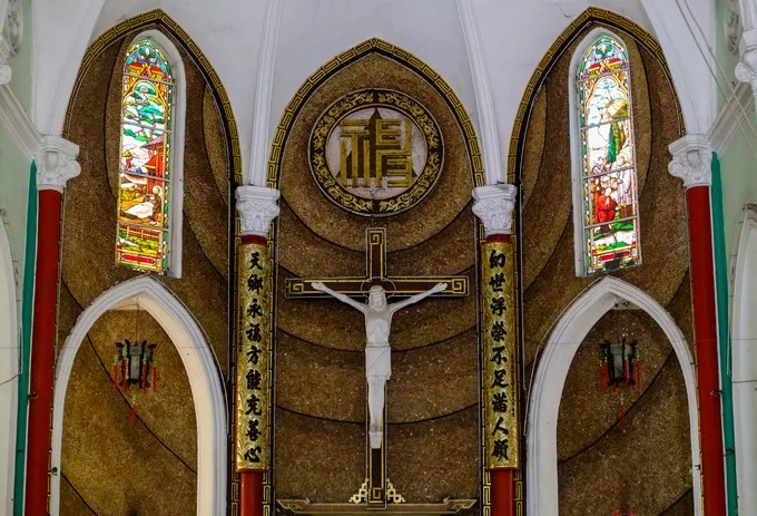 Tuy nhiên, bốn cây cột nơi cung thánh lại sơn đỏ - màu đặc trưng trong kiến trúc tôn giáo Trung Hoa. Hai bên hình tượng Chúa Giêsu bị đóng đinh là hai bức liễn sơn son thiếp vàng, chạm chữ màu đen.
