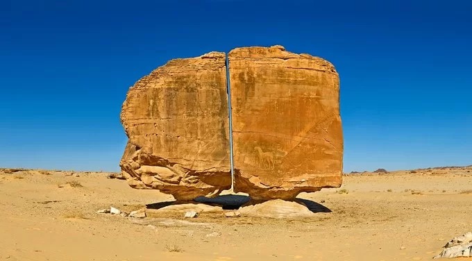 Thế giới có nhiều điểm đến kỳ lạ gợi sự tò mò của khách du lịch và các nhà nghiên cứu. Một trong số đó là khối đá Al Naslaa nằm ở ốc đảo Tayma, Arab Saudi, với đường cắt được cho là hoàn hảo như sử dụng kỹ thuật laser hiện đại chia đôi khối đá và những hình vẽ bí ẩn trên bề mặt. Ảnh: Unusual Place.