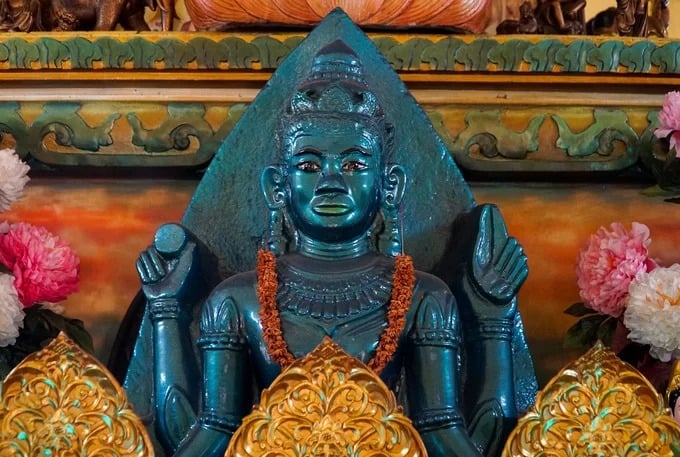 Giữa cột chánh điện thờ một bức tượng đá trong tư thế ngồi, cao 1,5 m, nặng gần một tấn. Pho tượng này là thần Vishnu do người Chăm tạc vào thế kỷ 15.  Năm 1861, người Pháp tìm thấy pho tượng này trong hốc cây gần chùa. Thấy vậy, các hương lão đến xin nhà cầm quyền Pháp rước tượng về để thờ trong chùa. Từ khi có tượng, người dân trong vùng cũng quen gọi là chùa Phật Bốn Tay.