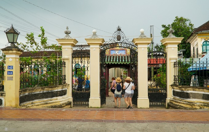 Từ mặt đường, đi qua chiếc cổng rào kiên cố, bạn sẽ thấy một cổng phụ xây theo kiến trúc Á Đông với 4 cột tròn, mặt trước gắn bảng "Phước An Hiệu".
