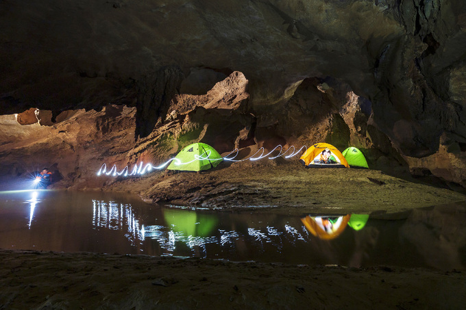 Du khách được cắm trại ngay trong lòng hang, bên cạnh là dòng nước mát lành.