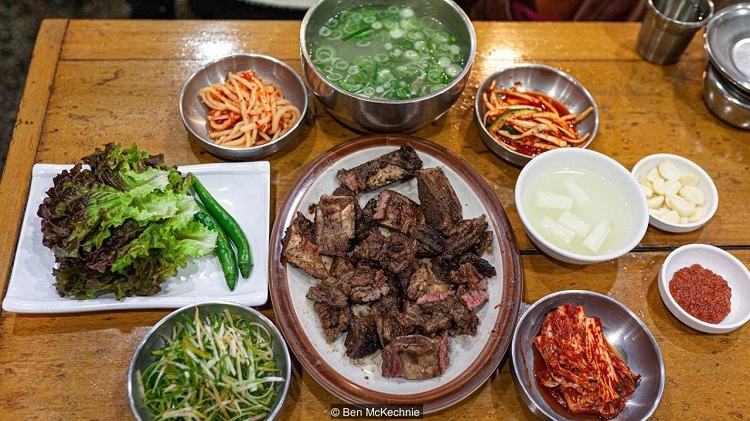 Thực khách ăn galbi có thể ăn kèm kimchi, rau diếp, ớt xanh và chấm sốt ớt. Ảnh: Ben Mckechnie.