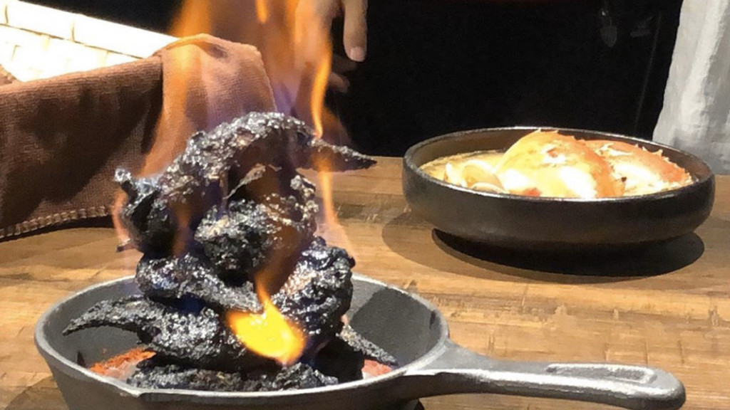 Thịt gà sau khi được ướp trong sữa đậu nành lên men truyền thống của Đài Loan sẽ được tẩm rượu và châm lửa để lớp da bên ngoài cháy đen. Món gà rán đen biểu tượng cho hình ảnh của địa ngục. Ảnh: CNN.