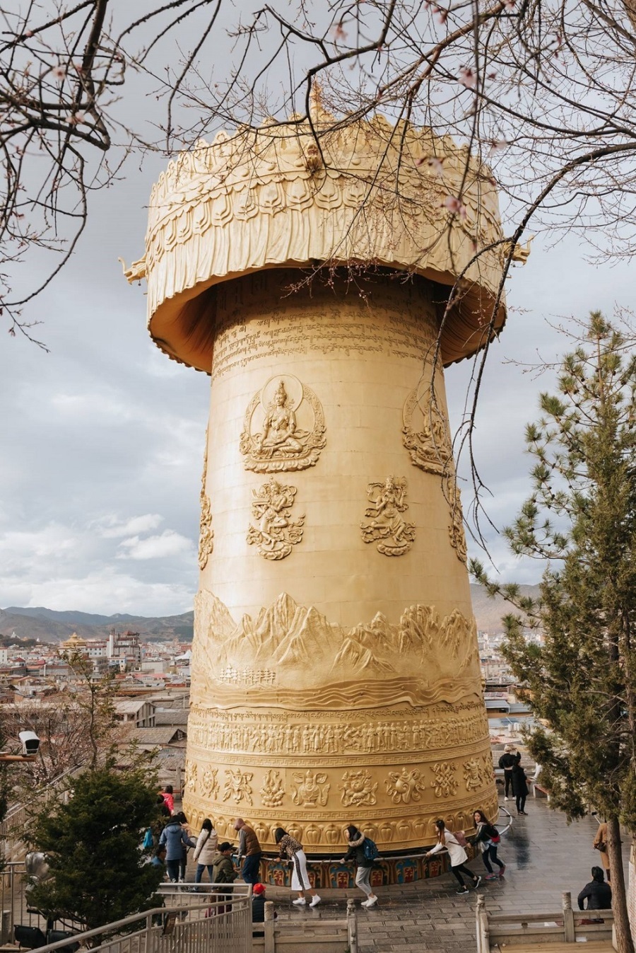   Bánh xe cầu nguyện, hay vòng quay Kim Luân, tại đền Dukezong (Độc Khắc Tông) là một bánh xe hình trụ, được làm từ kim loại, gỗ, đá, da thuộc hoặc sợi bông thô. Ở bên ngoài bánh xe là câu thần chú Om Mani Padme Hum được viết bằng ngôn ngữ Newari của Nepal.   Theo truyền thống Phật giáo Tây Tạng, việc quay một bánh xe như vậy sẽ có nhiều tác dụng tương tự như việc đọc lời cầu nguyện bằng miệng. Hiếu và nhóm bạn phải cần thêm những người khác để xoay bánh xe, thường là phải từ 10 người trở lên.