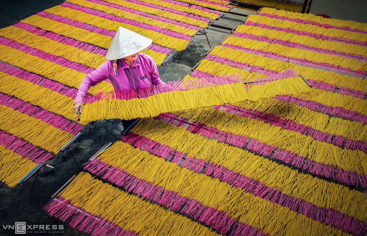 Người phụ nữ phơi hương trên những kệ dài tại khu phố Long Tân, phường Long Thành Bắc, Hòa Thành. Nhang Tây Ninh mang màu vàng hoặc nâu, không cuộn tròn từng bó.