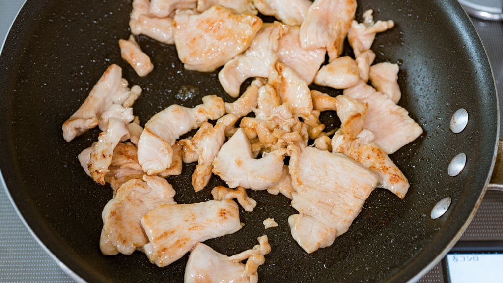 Stir-frying chicken for Pad Kee Mao recipe.