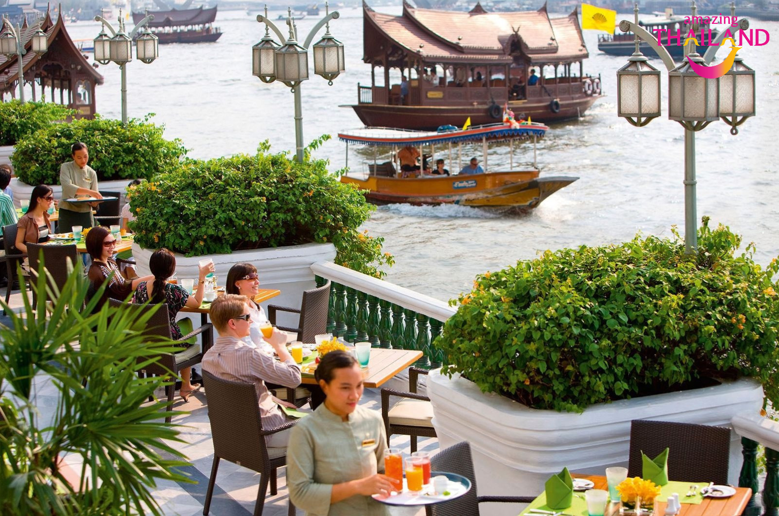 Khách du lịch ngồi thưởng thức đồ uống bên bờ sông Chao Phraya tại Bangkok, Thái Lan.